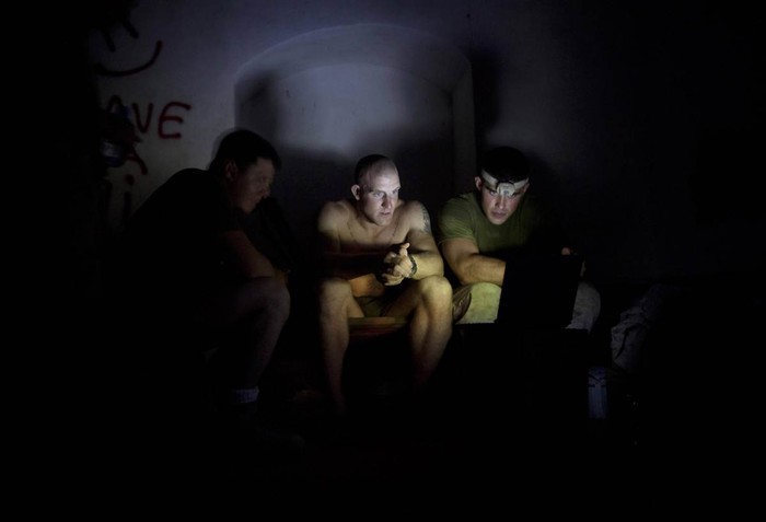 Các binh sỹ thuộc lực lượng lính thuỷ đánh bộ của Mỹ đang xem phim bằng laptop tại một căn cứ ở Helmand, Afghanistan.