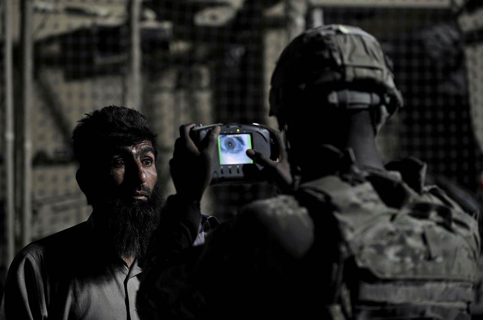 Một binh sỹ Mỹ đang sử dụng máy quét kỹ thuật lưu lại thông tin cá nhân từ mắt một người đàn ông Afghanistan ở Turkham Nangarhar (ảnh chụp ngày 28/9/2011).