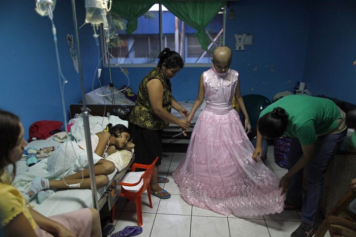 Một bé gái 15 tuổi đang thử váy mới nhân ngày sinh nhật của em ở bệnh viện nhi đồng ở La Mascota, Nicaragua.