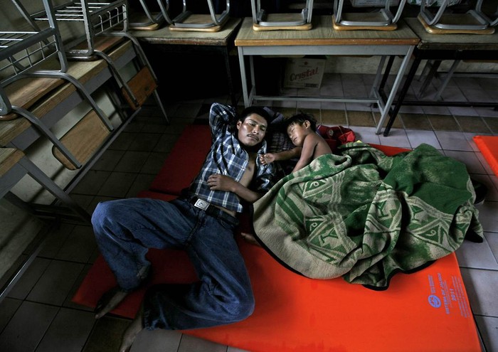 Hai bố con nằm ngủ trong khu vực tránh bão ở Jaluco, Mexico ngày 11/10/2011.