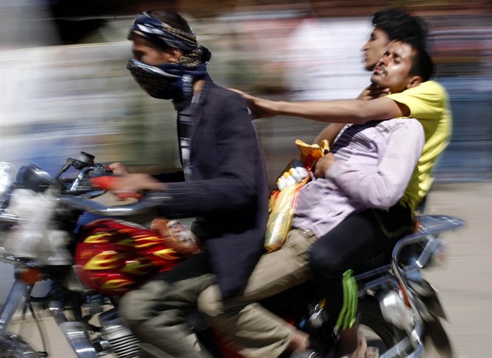 Một người biểu tình được chở đi cấp cứu bằng xe máy sau khi đụng độ với quân đội của Tổng thống Yemen tại thủ đô Sanaa.