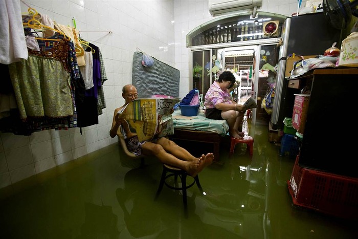 Một gia đình thường dân Thái Lan ở thành phố Băng Cốc ngồi đợi nước lụt từ con sông Chao Phraya rút đi.