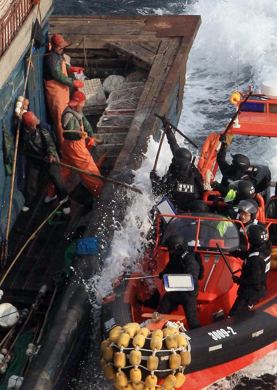Một cảnh tượng cho thấy ngư dân trên tàu cá Trung Quốc đang dùng dụng cụ chống lại an ninh Hàn Quốc khi bị yêu cầu dừng tàu để kiểm tra.