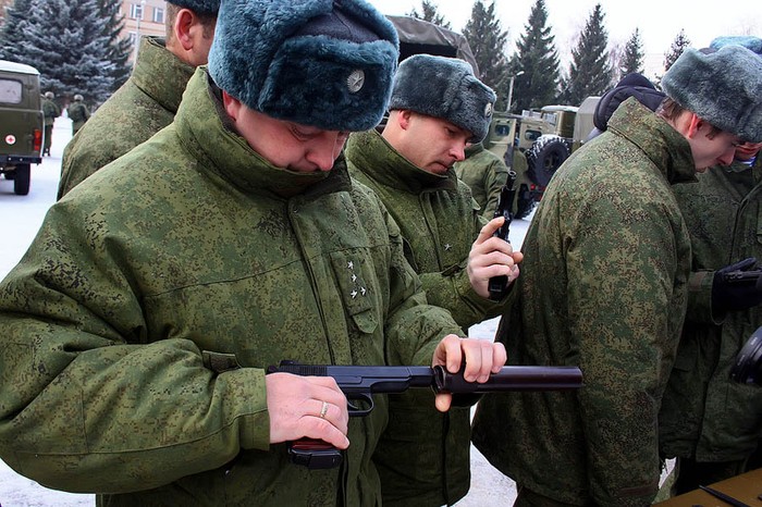 Sỹ quan Nga thao tác thử với một khẩu súng lục gắn đầu giảm thanh.