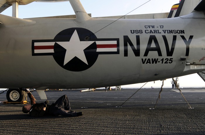 Thái Bình Dương: Nhân viên kỹ thuât đang kiểm tra cho chiếc máy bay cảnh báo sớm E-2C Hawkeye đang đậu trên tàu sân bay USS Carl Vinson (CVN 70).