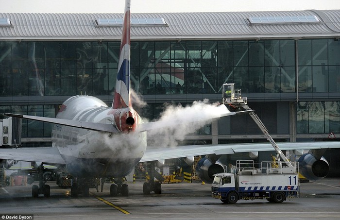 Làm sạch tuyết đóng băng trên thân máy bay ở phi trường Heathrow sáng 4/2/2012