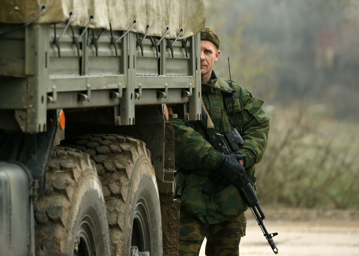 Một binh sỹ đứng phía sau xe vận tải chở quân