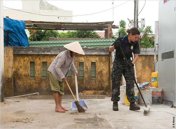 Carmen Drury đang quét sân cùng một phụ nữ Việt Nam