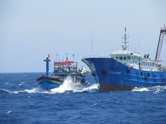 Tàu vỏ sắt giả danh tàu cá Trung Quốc (bên phải) đang truy đuổi tàu cá Việt Nam trên vùng biển Hoàng Sa. Ảnh: Laodong.com