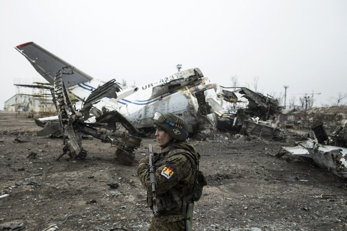 Một lính ly khai của quân đội của nhà nước tự xưng Donetsk đứng gác bên cạnh các mảnh vỡ của máy bay chở khách