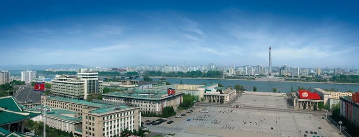 Ảnh chụp Giảng đường Nghiên cứu Nhân dân lớn, Quảng trường Kim Il-Sung và có cả Ngọn đuốc đỏ ở bên kia sông.