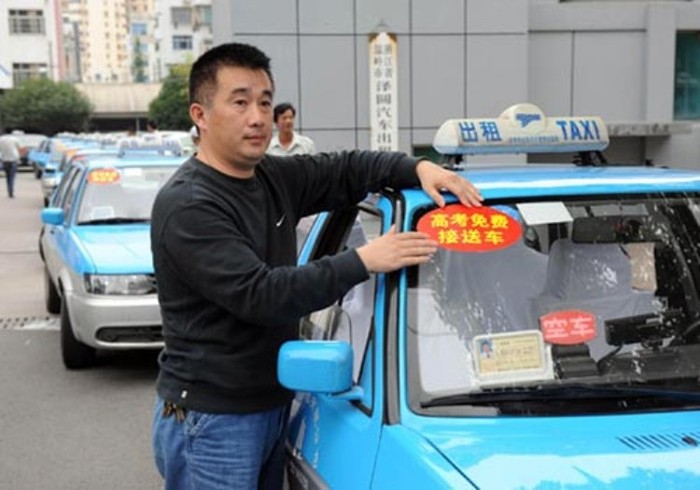 Bác lái xe đang dán biển "Miễn phí" cho chiếc taxi của mình để phục vụ các sĩ tử.
