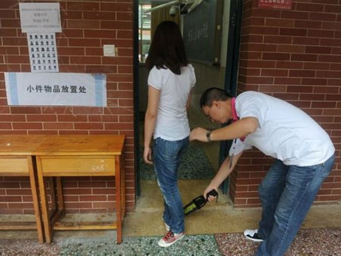 Một thí sinh được kiểm tra an ninh trước khi vào phòng thi. Ảnh: Dantri)