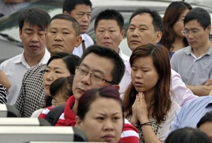 Một phụ nữ cầu nguyện bên ngoài địa điểm thi ở Nam Kinh, tỉnh Giang Tô. (Ảnh: Dantri)