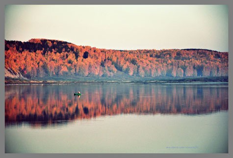 Cụ già chèo thuyền câu cá giữa sông trong ráng chiều mùa thu, bức tranh như phác họa một câu chuyện cổ tích.