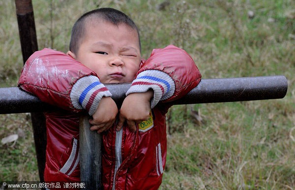 Cậu bé Yang Nieyuanzhang, 5 tuổi, chơi trên xà kép.