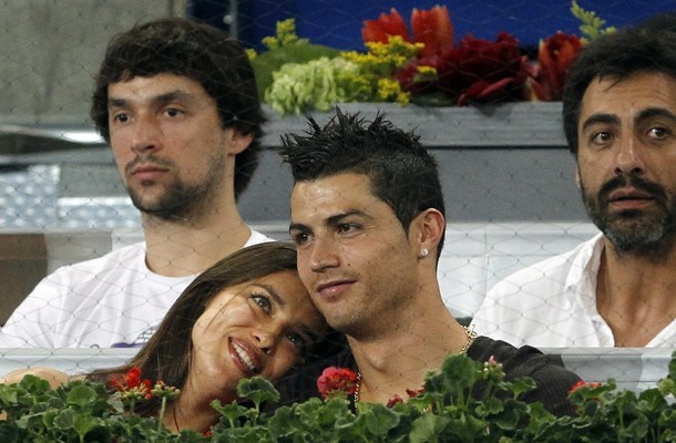 Cristiano Ronaldo và bạn gái Irina Shayk ngồi ở khu vực khán đài VIP được trang trí hoa tươi và hàng rào sắt bảo vệ.