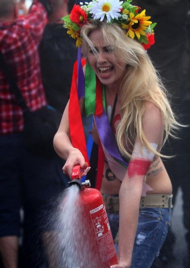 Người đẹp ngực trần dùng bình cứu hỏa xịt ngay trước sân vận động diễn ra lễ khai mạc EURO 2012 ở Warsaw, Ba Lan