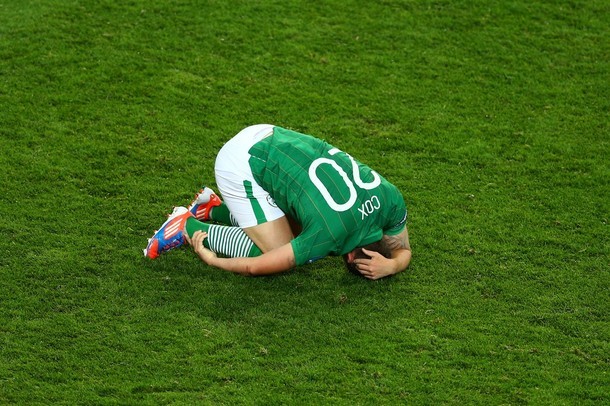 Cầu thủ Simon Cox của Ireland nằm úp mặt xuống sân sau khi trận đấu kết thúc.