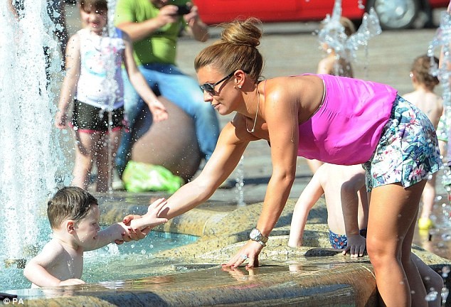Cậu nhóc Kai được mẹ cho phép đùa nghịch dưới vòi phun nước tại quảng trường thành phố Krakow, Ba Lan.