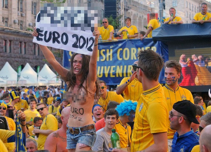 Người đẹp ngực trần giơ biểu ngữ phản đổi EURO 2012 tại fanzone dành cho các CĐV Thụy Điển trước trận đấu với Pháp ở Kiev, Ukraina