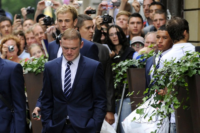 Wayne Rooney lộ rõ vẻ thất vọng khi cùng các đồng đội khác của đội tuyển Anh ra xe bus để tới sân bay về nước