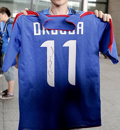 Một CĐV khoe chiếc áo số 11 kèm theo chữ ký của Drogba