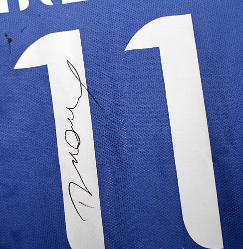 Một CĐV khoe chiếc áo số 11 kèm theo chữ ký của Drogba