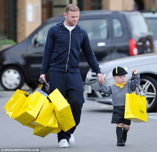 Kai giúp bố Rooney xách túi sau khi đi mua xắm tại Selfridges, London vào cuối tuần trước.