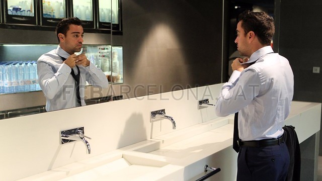 Xavi tự thắt cà vạt trong nhà vệ sinh.