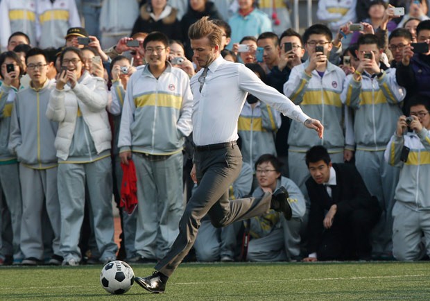 Trong bộ quần bó và áo chật, Becks có thể trình diễn các kỹ năng chơi bóng trước các em học sinh tại Bắc Kinh..