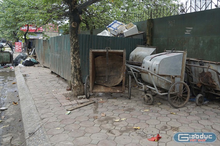 Rất nhiều xe gom rác cũ, hỏng, mục nát được vứt ngay trên vỉa hè suốt một thời gian dài. Ảnh: Tùng Dương.