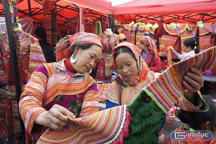 Thiếu nữ H&apos;Mông chọn mua trang phục truyền thống tại chợ Cốc Pài. Ảnh: Tùng Dương.
