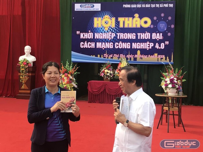 Giáo sư Nguyễn Lân Dũng đã tặng sách dạy cách trồng nấm cho cô giáo Nguyễn Thị Nhàn - Trường Trung học cơ sở Hùng Vương. Ảnh: Tùng Dương.