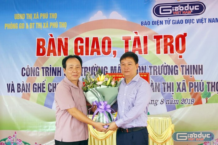 Ông Hà Tuấn Anh - Phó chủ tịch thị xã Phú Thọ (người bên trái) đang tặng hoa cho Nhà báo Nguyễn Tiến Bình. Ảnh: Tùng Dương.