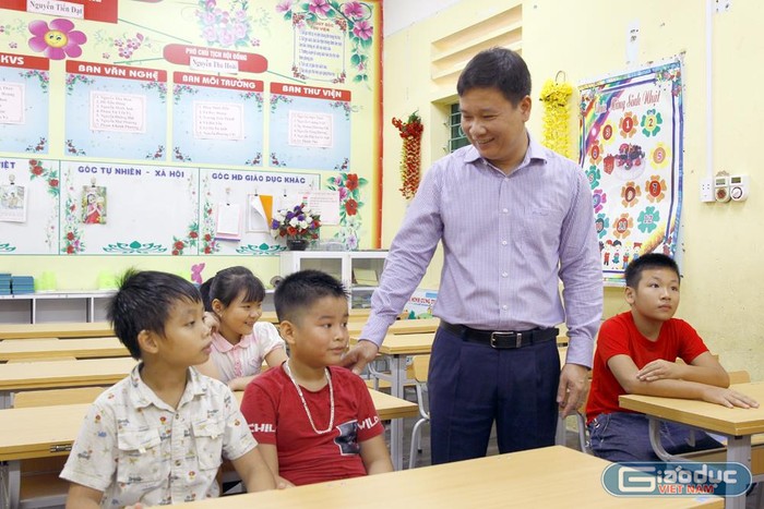 Nhà báo Nguyễn Tiến Bình - Tổng biên tập Báo điện tử Giáo dục Việt Nam đang hỏi thăm việc học tập của các em học sinh tại Trường Tiểu học Lê Đồng. Ảnh: Tùng Dương.