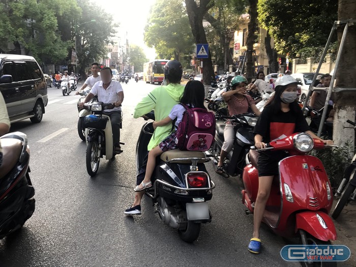 Phụ huynh đón con đi ngược chiều trên phố Nguyễn Thái Học, Hà Nội. Ảnh: Tùng Dương.