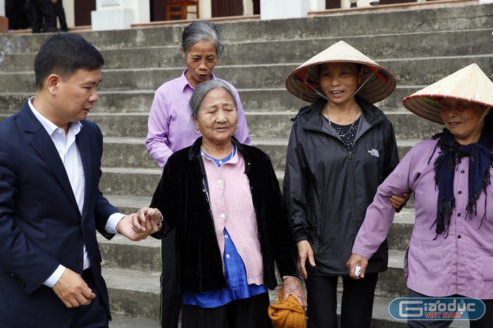 Nhà báo Nguyễn Tiến Bình - Tổng biên tập Báo điện tử Giáo dục Việt Nam đang thăm hỏi bà Khúc Thị Bình, 87 tuổi. Ảnh: Tùng Dương.