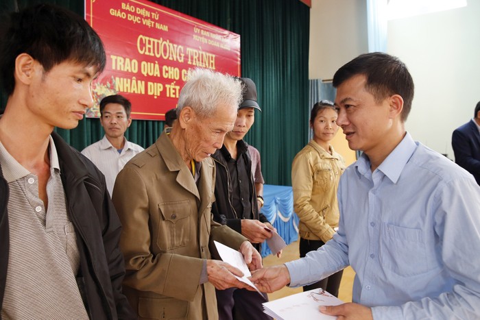 Ông Bùi Chí Kiên - Chủ tịch Ủy ban nhân dân xã Hùng Xuyên, đang trao quà cho các hộ nghèo của xã Hùng Xuyên. Ảnh: Tùng Dương