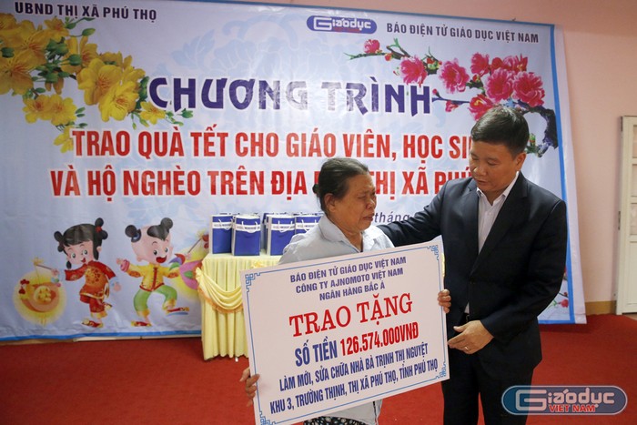 Nhà báo Nguyễn Tiến Bình - Tổng biên tập Báo điện tử Giáo dục Việt Nam trao tặng số tiền để làm mới và sửa chữa căn nhà cho bà Trịnh Thị Nguyệt 67 tuổi. Ảnh: Tùng Dương.
