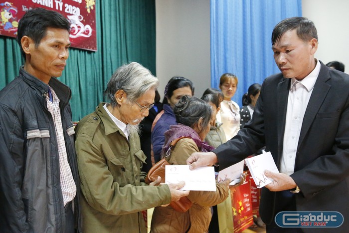Ông Nguyễn Xuân Tú - Chủ tịch Ủy ban nhân dân xã Yên Dưỡng, trao quà Tết cho các hộ có hoàn cảnh khó khăn trong xã. Ảnh: Tùng Dương.