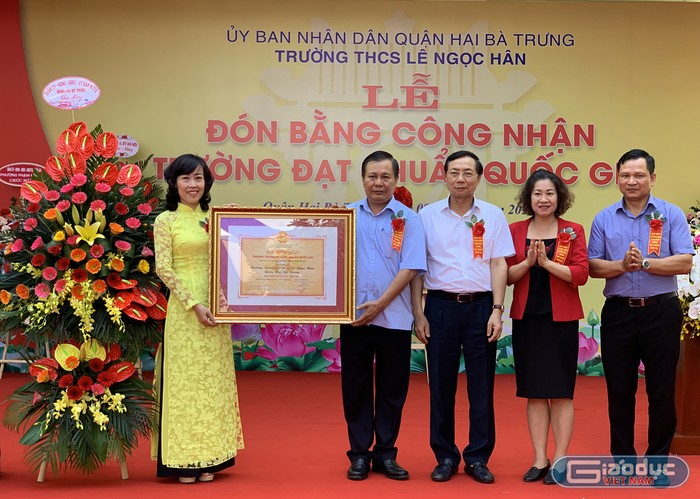 Nhà giáo Nguyễn Thị Kim Khuê - Hiệu trưởng Trường Trung học Cơ sở Lê Ngọc Hân (ngoài cùng bên trái) nhận Bằng công nhận trường đạt chuẩn Quốc gia. Ảnh: Tùng Dương.