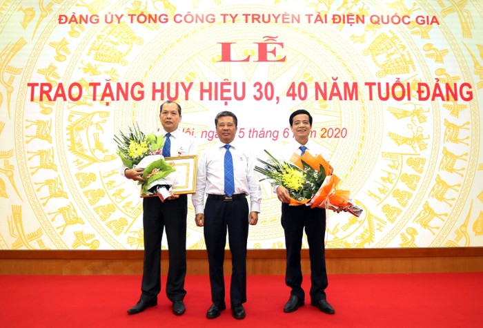 Đồng chí Đặng Phan Tường - Bí thư Đảng ủy, Chủ tịch Hội đồng thành viên EVNNPT trao Huy hiệu và tặng hoa chúc mừng hai Đảng viên nhận danh hiệu 30 năm và 40 năm tuổi Đảng.