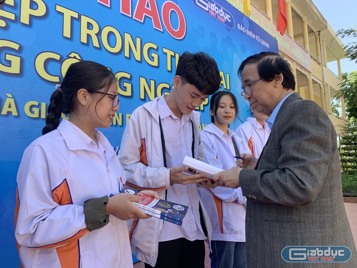 Nhà giáo nhân dân - Giáo sư Nguyễn Lân Dũng đang tặng sách cho đại diện các em học sinh Trường Trung học phổ thông Gang Thép. Ảnh: Tùng Dương.