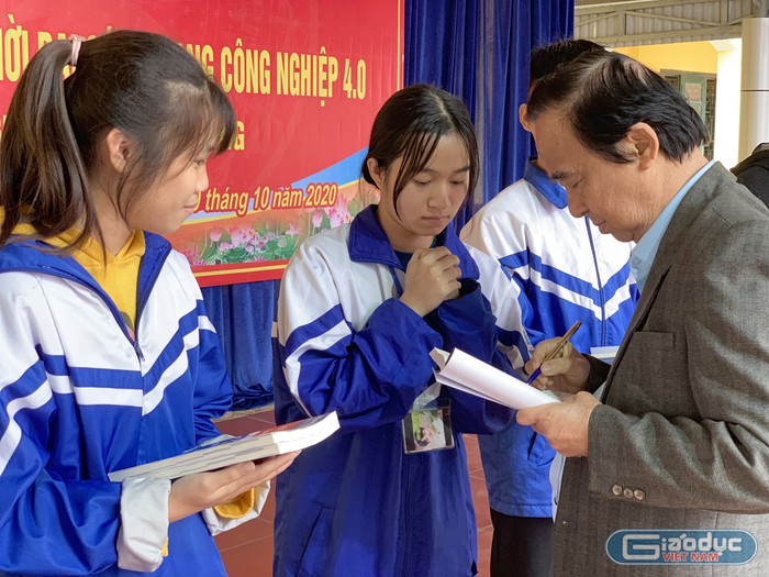 Giáo sư Nguyễn Lân Dũng tặng sách cho đại diện các em học sinh của trường. Ảnh: Tùng Dương.