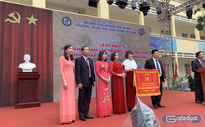Ban giám hiệu Trường Trung học phổ thông Yên Hòa nhận Cờ thi đua của Chính phủ trao tặng trong lễ kỷ niệm. Ảnh: Tùng Dương.