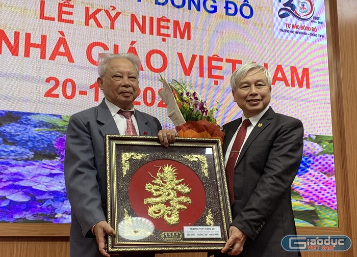 Tiến sĩ Võ Thế Quân (bên phải ảnh) - Hiệu trưởng Trường Trung học phổ thông Đông Đô trao kỷ niệm chương cho Giáo sư Nguyễn Mậu Bành. Ảnh: Tùng Dương.