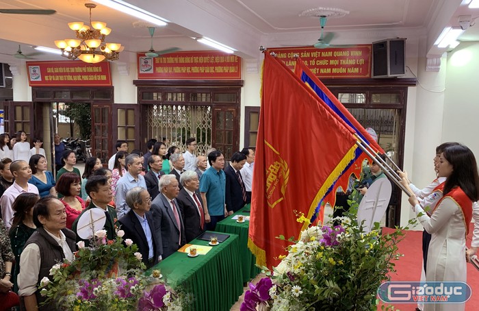 Các đại biểu tham dự lễ kỷ niệm ngày nhà giáo Việt Nam tại Trường Trung học phổ thông Đông Đô đang làm lễ chào cờ. Ảnh: Tùng Dương.