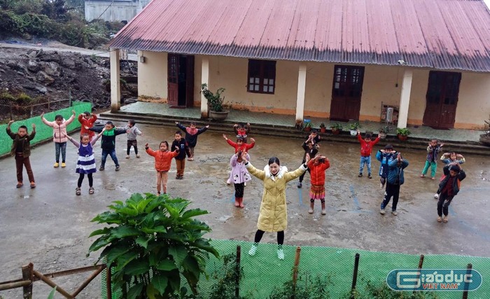 Cô Lồ Thị Lan, người dân tộc Bố Y - Giáo viên dạy lớp 1 Trường Tiểu học số 2 thị trấn Mường Khương, tỉnh Lào Cai và các em học sinh trong giờ thể dục. Ảnh: Nhân vật cung cấp.