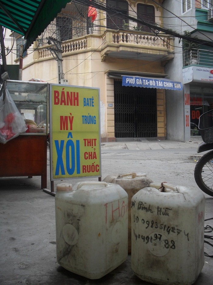 Tiệm hàng bánh mì pa-tê của chị Ngô Thị Phương (Hoàng Mai) phải mua từng can nước để sử dụng.